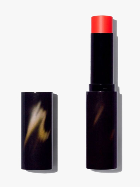 Victoria Beckham Beauty Cheeky Posh Cream Blush Stick black twist up stick of bright red blush with cap to the side on light gray background